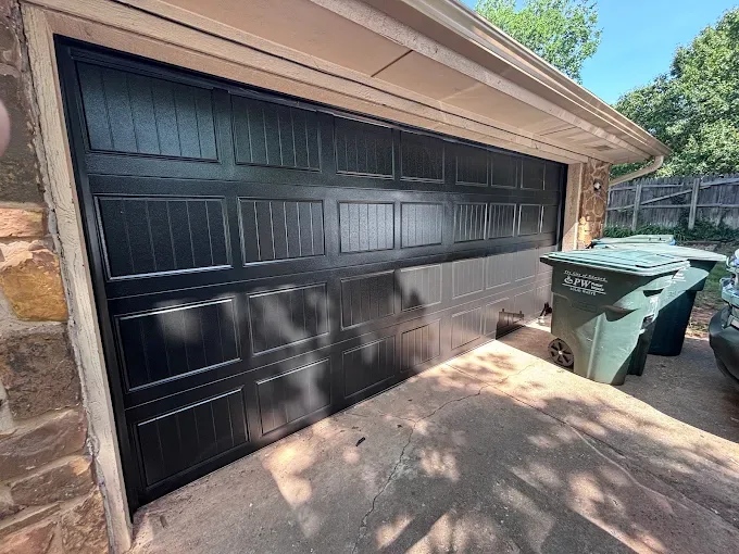 Black raised panel garage door on brick home installed by Affordable Door Co in Oklahoma City